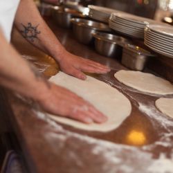 Das Gelingen einer Pizza hängt auch vom Umgang mit den rohen Teig ab - unsere Köche beherrschen diesen perfekt
